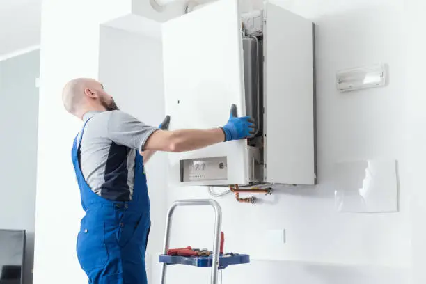 Technician inspecting water heater controls and fittings with professional diagnostic attention