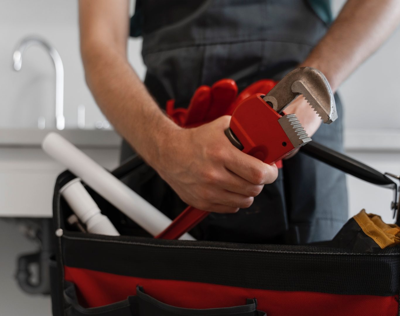 Professional Plumbing Company In Greensboro, NC, Experienced plumber inspecting bathroom plumbing carefully to recommend cost-effective repairs